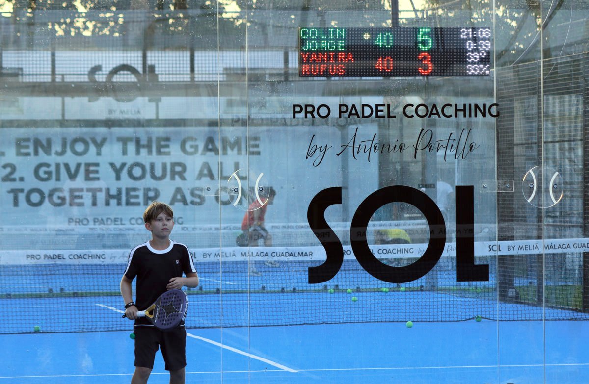 Niño en pista de pádel con marcador LED Unoth mostrando el resultado del partido