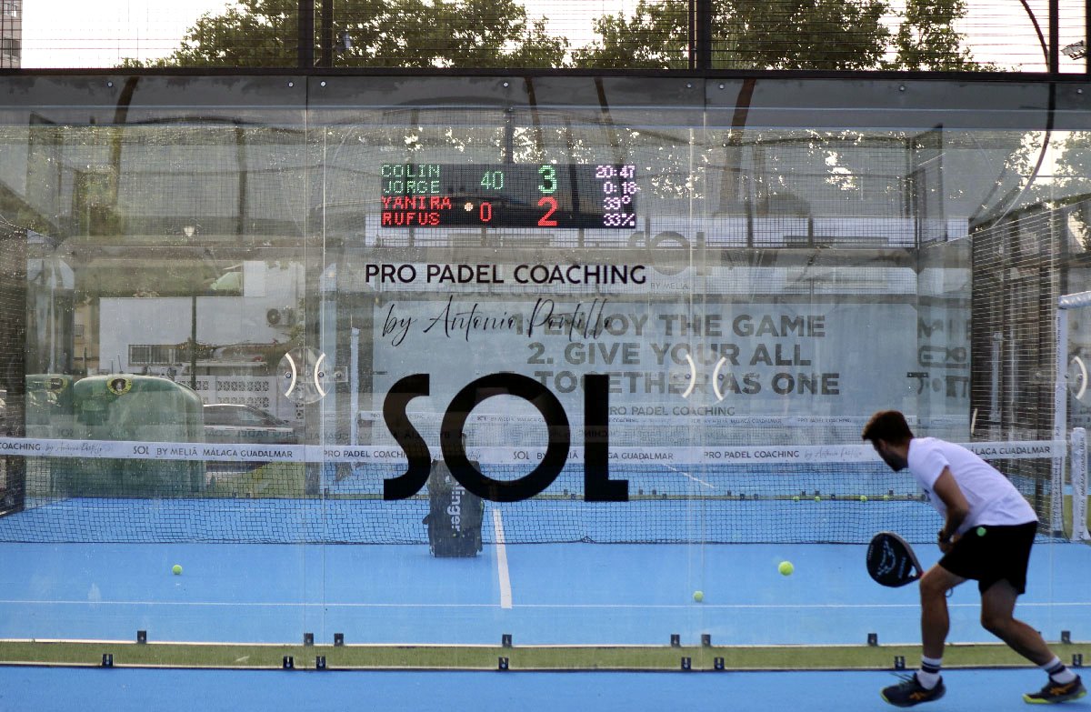 Jugador de pádel en pista outdoor con marcador LED Unoth al fondo