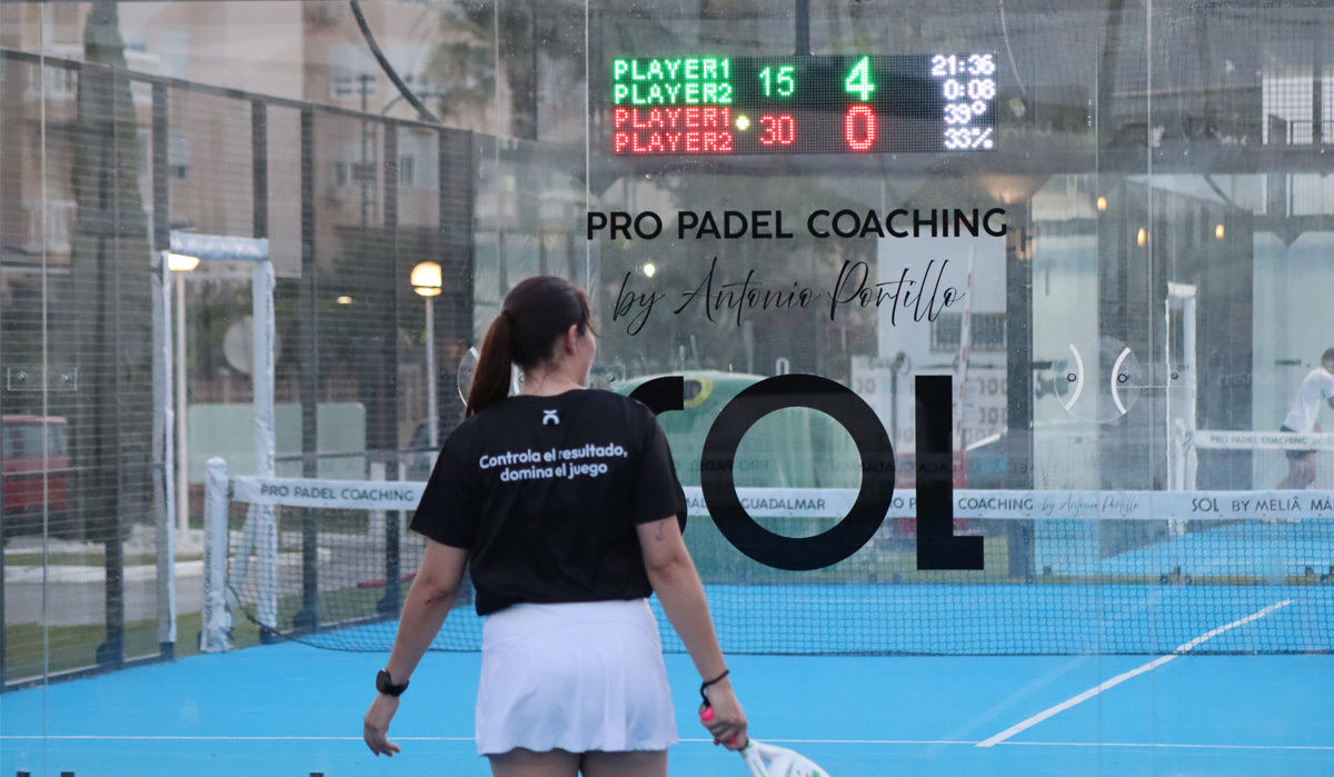 Jugadora de pádel con camiseta Unoth frente a pista con marcador LED activo